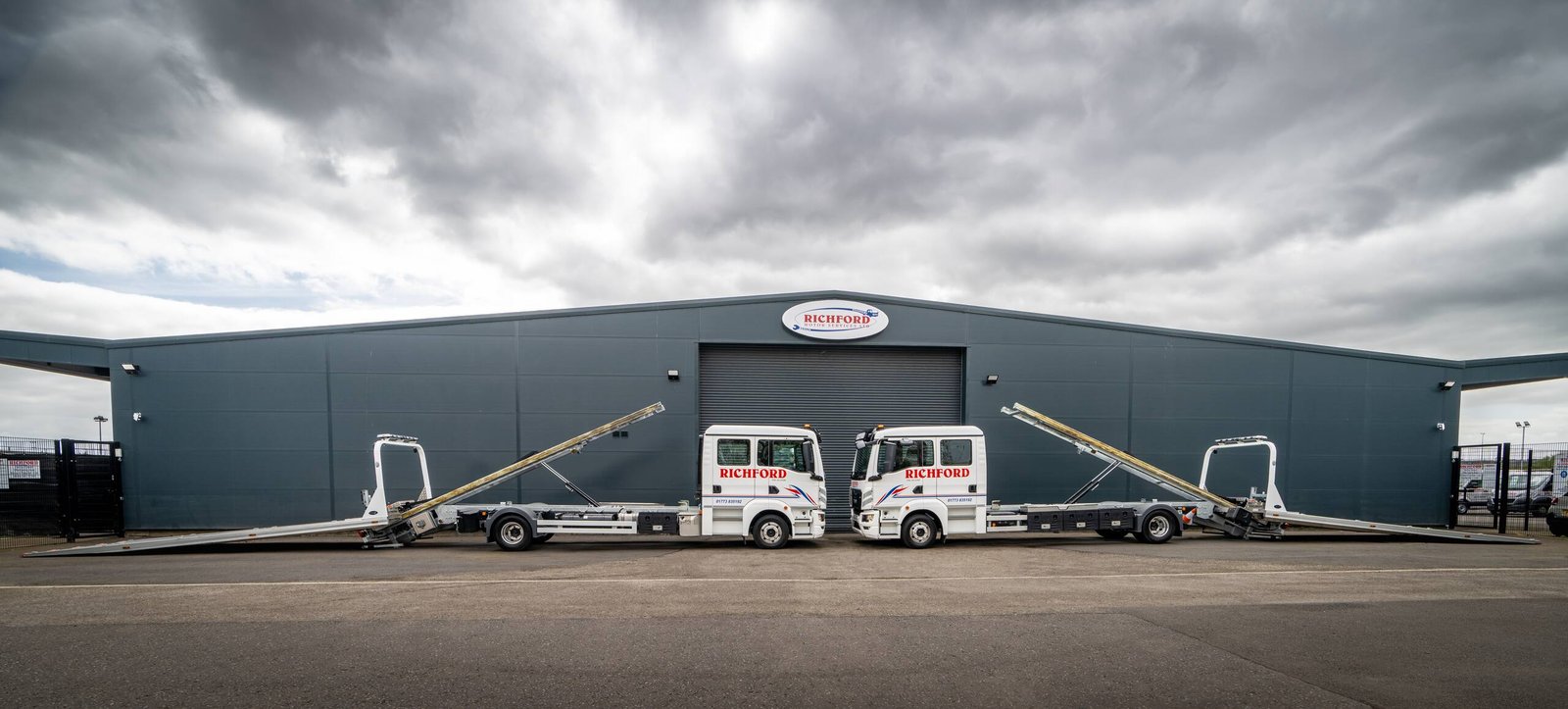 Richfords crew cab slidebed recovery trucks with ramps deployed outside the Richford Motors depot